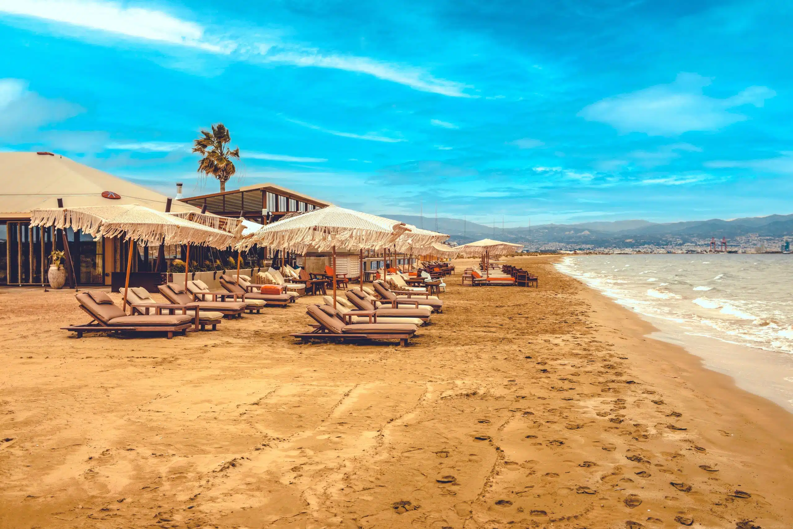 Wooden,Sun,Loungers,With,Soft,Cushions,Under,White,Parasols,On