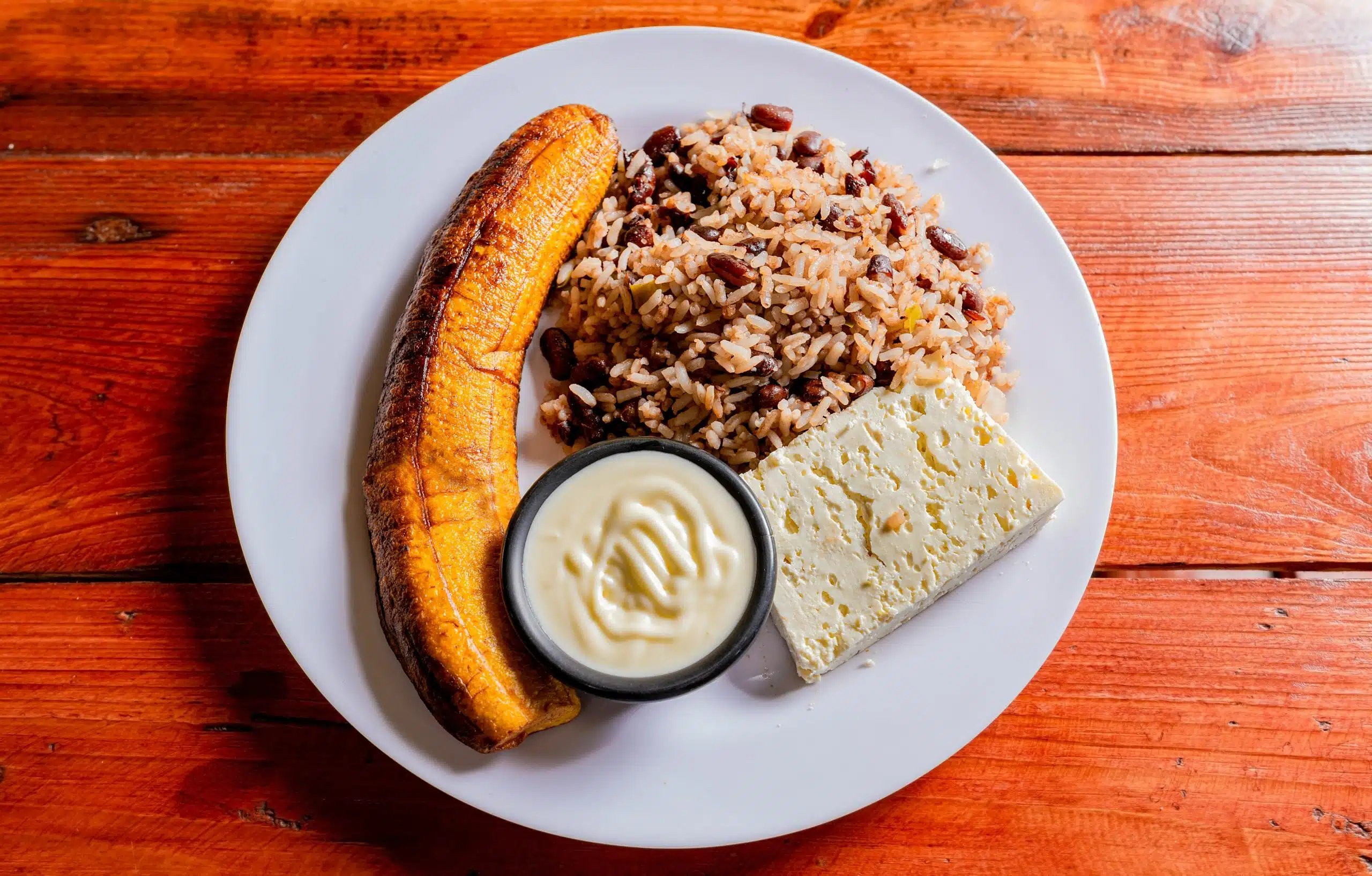 Gallopinto,Plate,With,Cheese,And,Maduro,On,Wooden,Table.,Nicaraguan